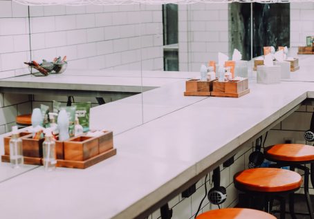 photo of bathroom with mirror, shampoo, conditioner, tissues, and stools